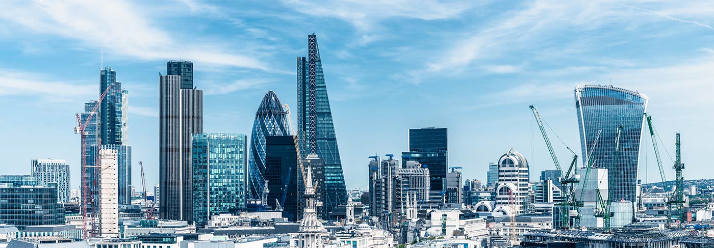 The London corporate skyline against a clear blue sky.